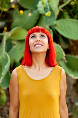 Pensive red haired woman in a park looking up