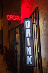 Drink neon sign at the entrance of a bar