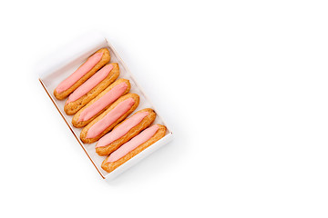 Open delivery paper box with six fresh pink cupcakes on white background. Top view, space for text. Unhealthy or dieting concept.