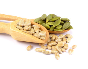 Pumpkin seeds and sunflowers seeds in wooden spoon isolated on white background