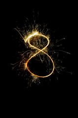 "8" number drawn with bengali sparkles isolated on black backgroundnumber from sparkler on black background
