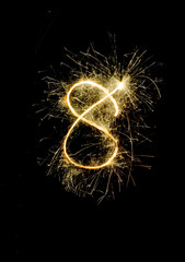 "8" number drawn with bengali sparkles isolated on black backgroundnumber from sparkler on black background