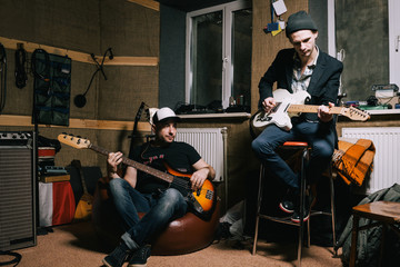 Fototapeta premium Band of adult guitarists rehearsing in studio. Grown-up musicians, creative hobby for hipsters, music repetition