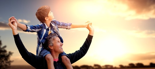 Composite image of father carrying his son on his shoulders