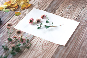 Naklejka na ściany i meble Dried flowers with autumn leaves on a wooden background.