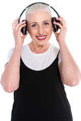 Senior woman in big headphones