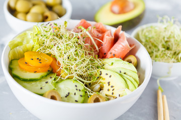salmon poke with rice, avocado and sprouts.