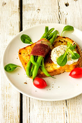 Poached egg on a piece of bread on the wooden table
