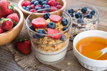 Healthy breakfast,  yogurt with flasks, honey  and berries on rustic wooden table