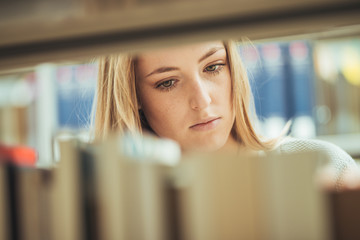 pretty female student learning in a high school library