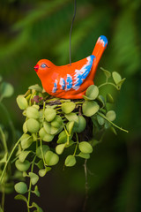 Wooden orange bird in a garden