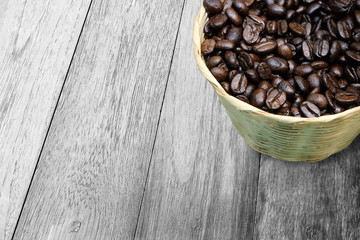 Coffee beans in basket on wood texture