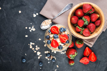 Fototapeta na wymiar Healthy breakfast, natural yoghurt with fresh berries and muesli on a dark background