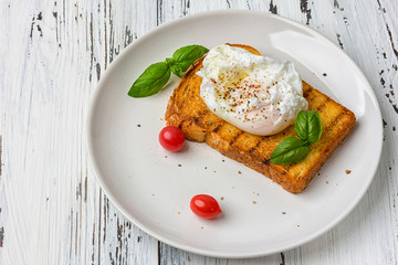 Poached egg on a piece of bread on the wooden table