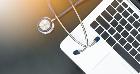 Top view and Closed up ,Laptop and stethoscope on desk.with non-text on keyboard ,with copy space