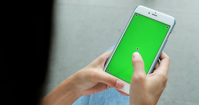 Woman using cellphone with chroma key