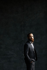 Handsome caucasian businessman dressed in the suit near the window in the loft interior studio