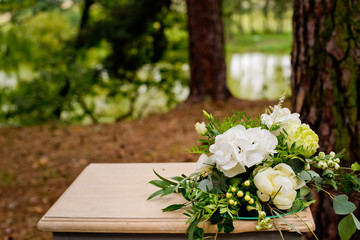 White flowers on a table in the forest. Wedding decorations.