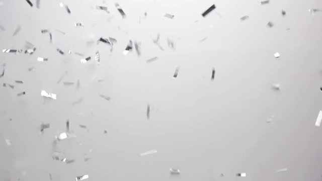 silver confetti falling over white background