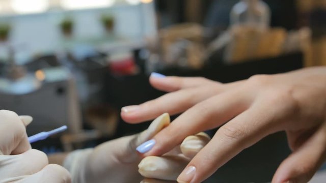 Master in gloves makes a manicure close-up
