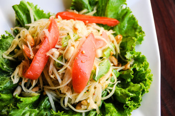 Papaya Salad, Shredded green papaya, tomatoes, green beans, crushed peanut & lime dressing.