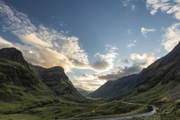 Late afternoon view of the A82 highway snaking its way through the Lost Valley including the The Three Sisters Beinn Fhada, Gearr Aonach, and Aonach Dubh in the Scottish Highlands.