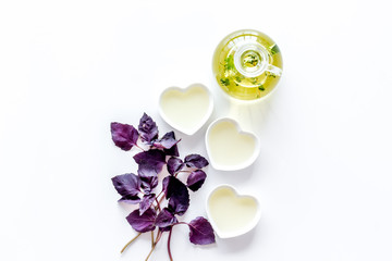 Bottle with organic oil with herbs ingredients on white background top view mockup