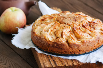 Easy apple tea cake on a wooden background. Homemade baking.