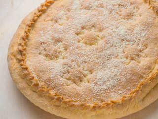 round pie with filling on a table