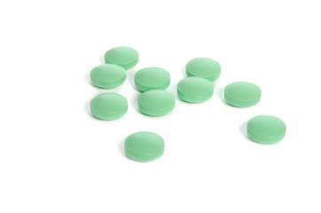 Pile of light green pills isolated on white background