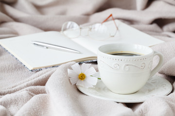 mug of morning coffee in bed, reading a book, spring flower