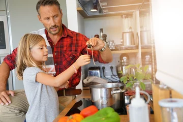 Photo sur Plexiglas Cuisinier Daddy with daughter cooking together in home kitchen