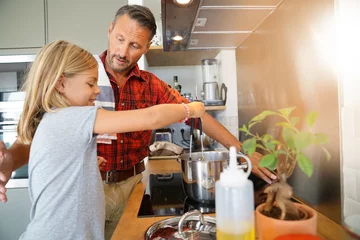 Crédence de cuisine en verre imprimé Cuisinier Papa avec sa fille cuisiner ensemble dans la cuisine à domicile