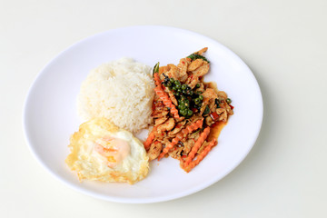 stir fried chicken with roasted chili paste and fresh Piper nigrum on jasmine rice in white plate on white background. Thai style food.
