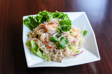 Yum Woonsen Glass Noodle Salad, Glass noodles salad served on a bed of lettuce with chicken and shrimp.