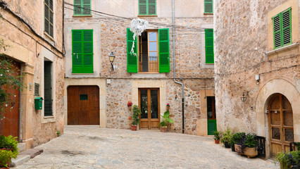 Fototapeta na wymiar small empty square in the village of Valldemossa surrounded by traditional houses