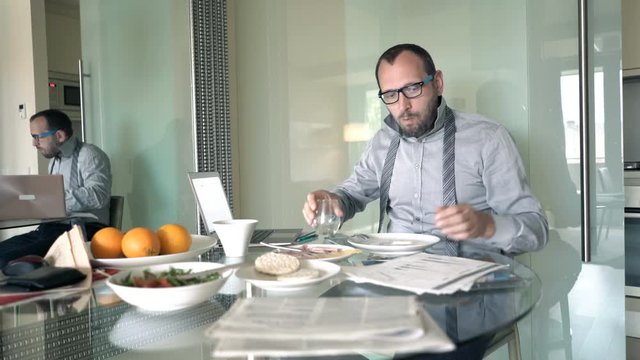 Young businessman finishing breakfast and leaving home 
