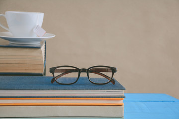 Book glasses and tea on the desk with study and education concept