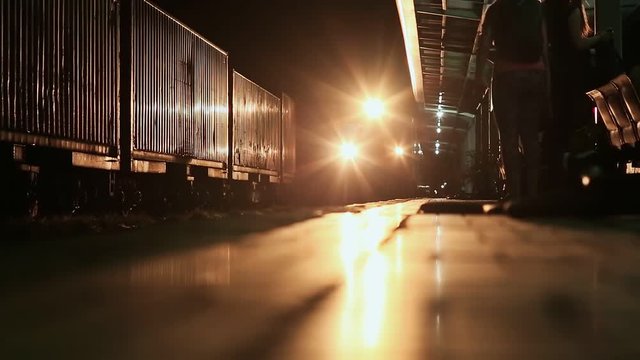 The train at night arrives at the platform of the railway station. Vietnam.