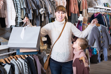 Fototapeta premium Happy pregnant female and girl enjoying purchases