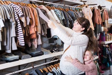Fototapeta premium Pregnant woman examining baby's clothes