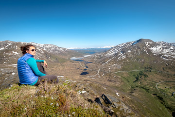 Young female hiker enjoying beautiful view of dramatic landscape in a Norway.