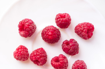 raspberries on a white saucer close up