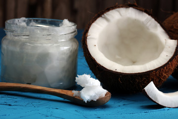 coconut oil and fresh coconuts on blue background