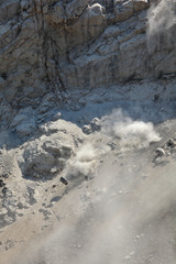 Stone avalanche in mountains, rocks and dust fall down