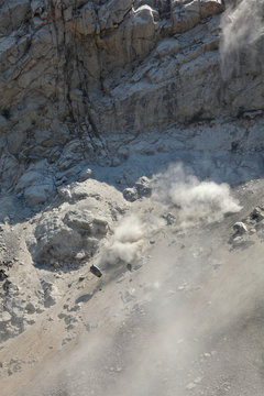 Stone avalanche in mountains, rocks and dust fall down