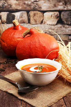 Roasted pumpkin and carrot soup with cream and pumpkin seeds on
