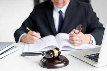 lawyer hand writes the document in court (justice, law) with sounding block