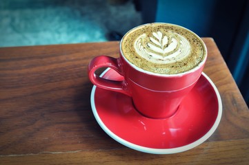 red  cup of hot coffee on wooden table in coffee shop,red cup