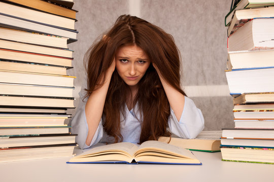 attractive young woman student undre stress while studiing for exames